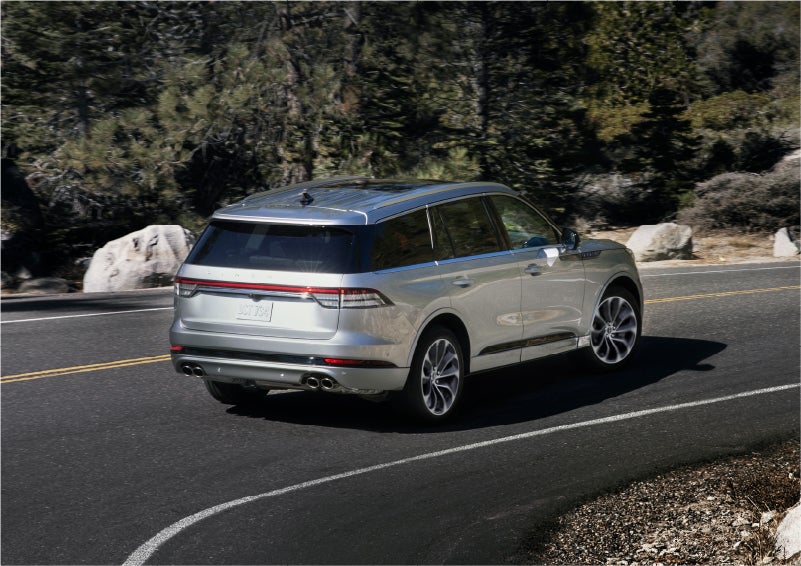 A 2023 Lincoln Aviator® Grand Touring model is shown being driven on a tight turn of a mountain road | Buss Lincoln in McHenry IL