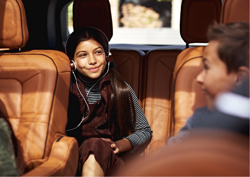 Two young people are shown comfortably seated in the second and third rows of a Lincoln Aviator® SUV | Buss Lincoln in McHenry IL