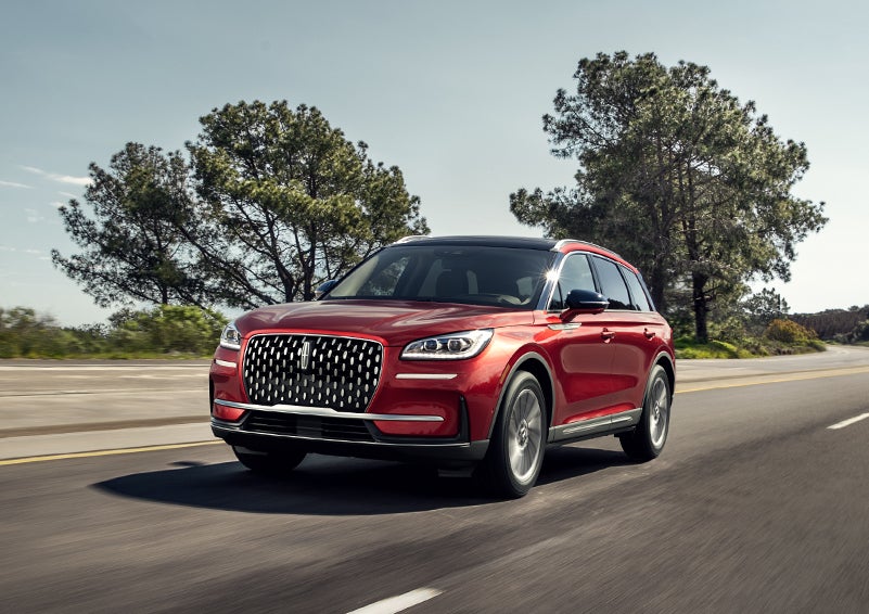 A 2024 Lincoln Corsair® SUV is shown being driven on a country road. | Buss Lincoln in McHenry IL
