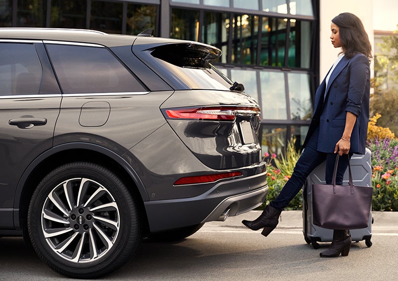 A woman with her hands full uses her foot to activate the available hands-free liftgate. | Buss Lincoln in McHenry IL