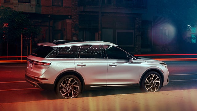 The 2024 Lincoln Corsair® SUV is parked on a city street at night. | Buss Lincoln in McHenry IL
