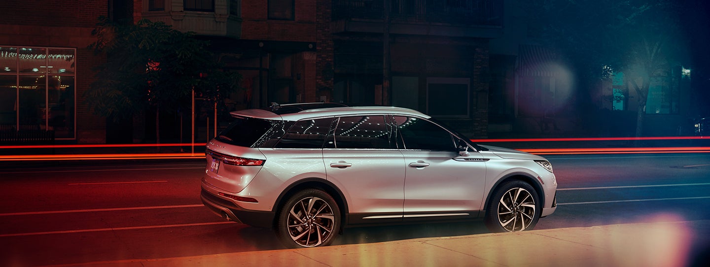 The 2024 Lincoln Corsair® SUV is parked on a city street at night. | Buss Lincoln in McHenry IL