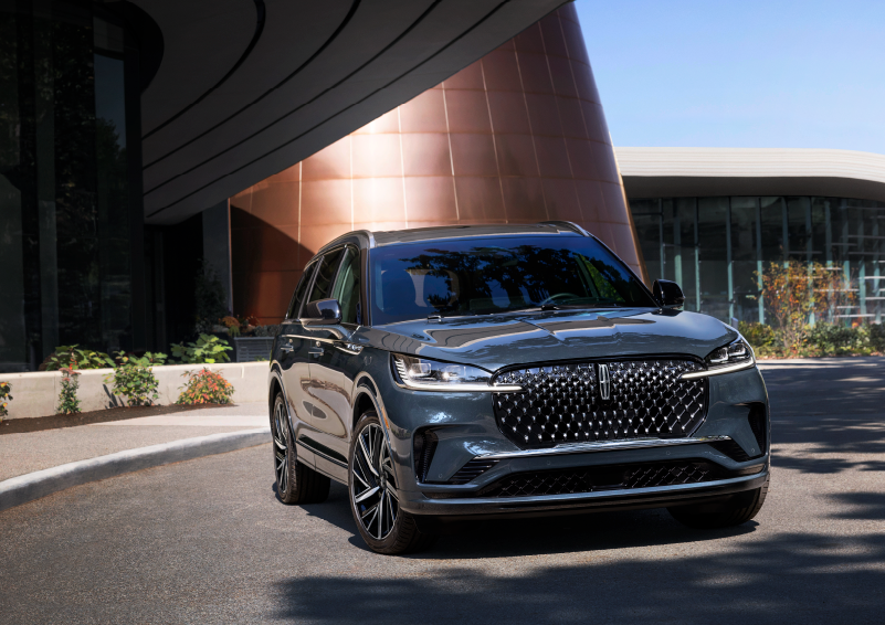 A gray 2025 Lincoln Aviator® SUV is parked outside a modern building with the sun shining. | Buss Lincoln in McHenry IL