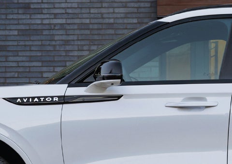 The driver’s side door and fender badging of a white 2026 Lincoln Aviator® SUV are showcased. | Buss Lincoln in McHenry IL