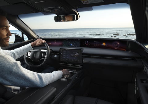 A driver of a parked 2026 Lincoln Nautilus® SUV takes a relaxing moment at a seaside overlook while inside his Nautilus. | Buss Lincoln in McHenry IL