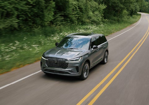 A 2027 Lincoln Aviator® SUV is being driven down a road. | Buss Lincoln in McHenry IL
