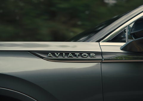 The driver’s side door and fender badging of a gray 2027 Lincoln Aviator® SUV are showcased. | Buss Lincoln in McHenry IL