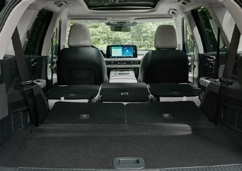 A rear to front view of the interior of a 2027 Lincoln Aviator® Black Label™ SUV shows the third and second rows folded flat | Buss Lincoln in McHenry IL