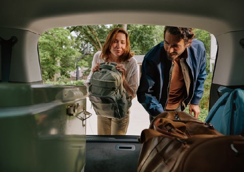 A couple loads luggage into the rear of a 2027 Lincoln Aviator® Black Label™ SUV..e 202 | Buss Lincoln in McHenry IL
